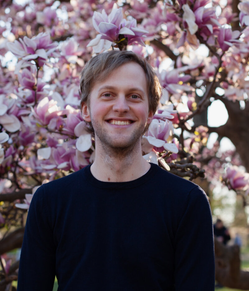 Portrait of Jeroen Olieslagers in front of a blossoming magnolia tree